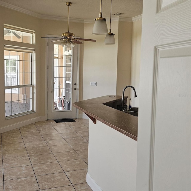 kitchen featuring ornamental molding, light tile patterned flooring, dark countertops, and visible vents