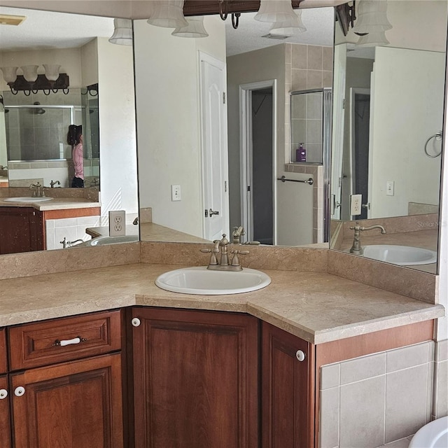 full bathroom featuring vanity, visible vents, and a shower stall