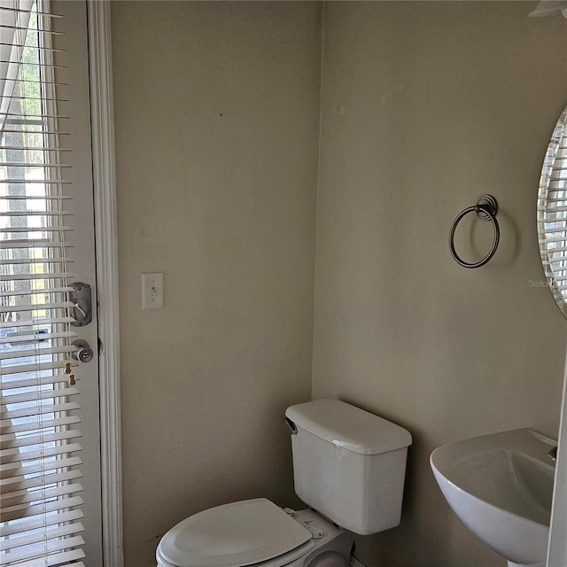 half bath featuring toilet and a sink
