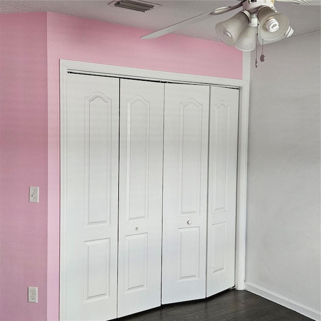 interior space with wood finished floors, visible vents, baseboards, and ceiling fan