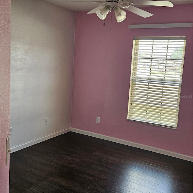 empty room with dark wood-style floors, baseboards, and ceiling fan