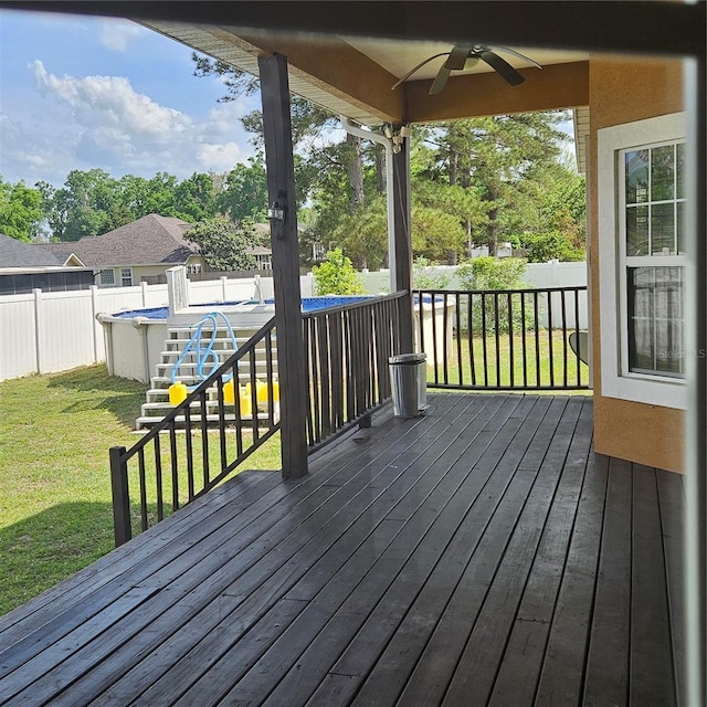 wooden deck with a fenced backyard, a fenced in pool, a yard, and ceiling fan