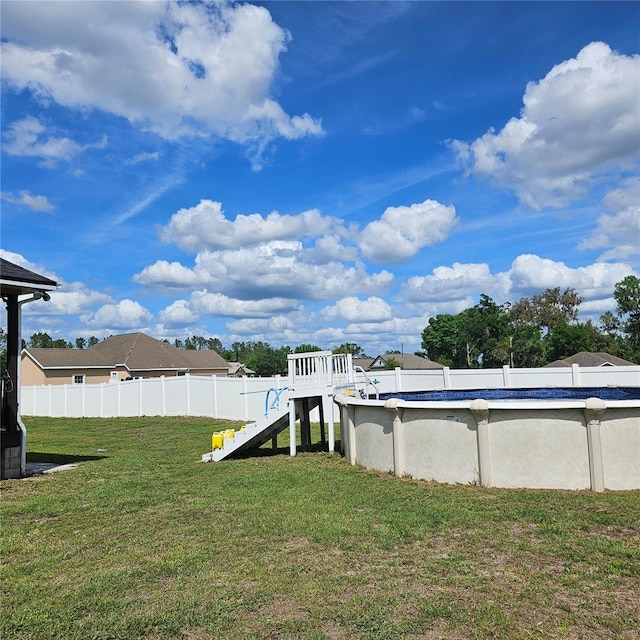 view of yard featuring a playground, a fenced in pool, and fence