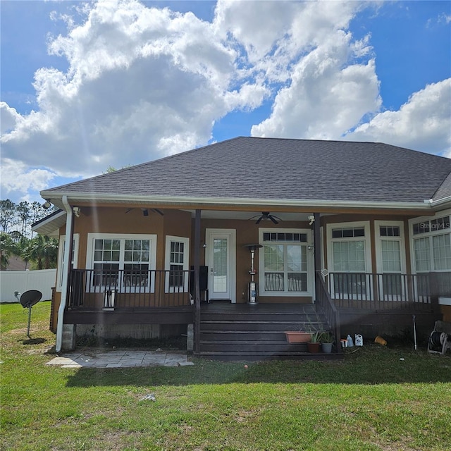 view of front of property featuring covered porch, a shingled roof, a front lawn, and a ceiling fan
