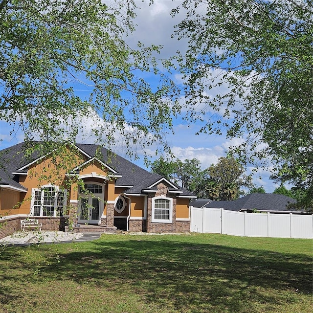 view of front of property featuring a front yard, stucco siding, and fence