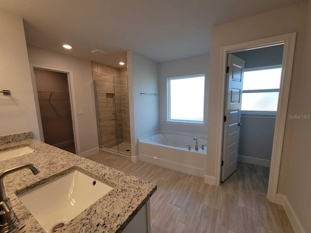 9553 SW 42nd Ave, Ocala, FL 34476 - bathroom with a stall shower, a bath, double vanity, a spacious closet, and plenty of natural light