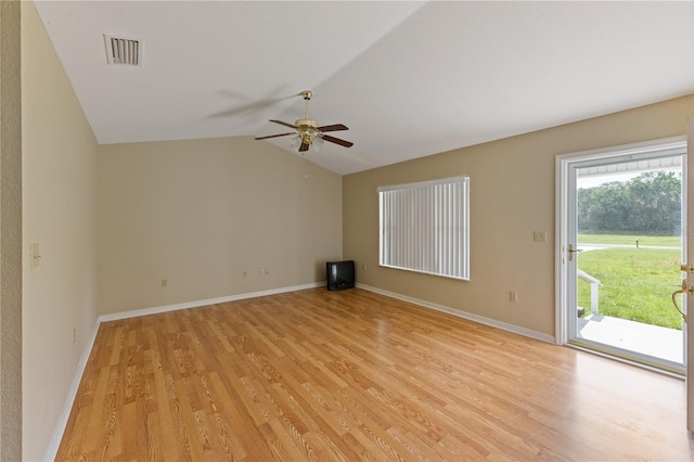 spare room featuring light wood finished floors, ceiling fan, vaulted ceiling, and visible vents