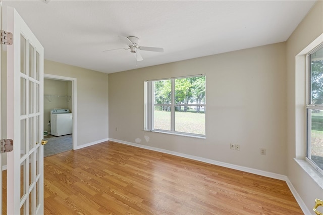 unfurnished room featuring washer / clothes dryer, ceiling fan, baseboards, and light wood-style flooring