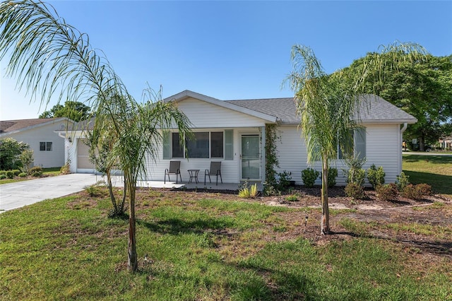 ranch-style home featuring concrete driveway, a front yard, a garage, and a shingled roof