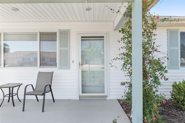 view of exterior entry with a patio area