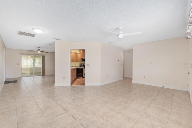unfurnished room with visible vents, baseboards, light tile patterned floors, a ceiling fan, and a textured ceiling