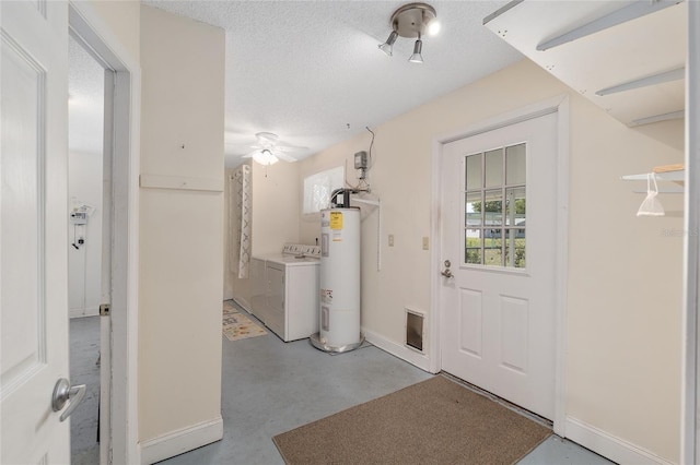 interior space featuring ceiling fan, a textured ceiling, water heater, washer / dryer, and baseboards