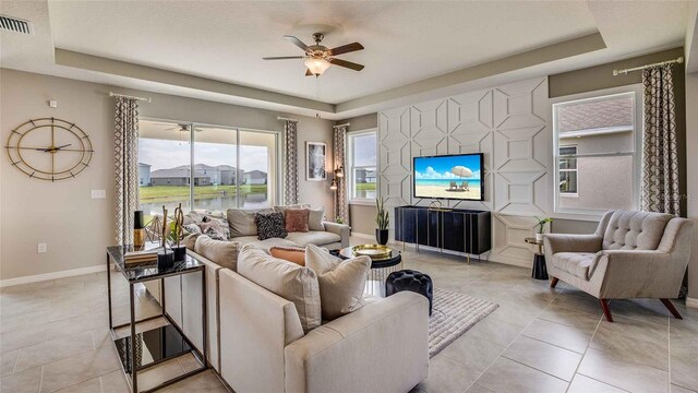 12833 NW 13th Ln, Newberry, FL 32669 - living room featuring a raised ceiling, ceiling fan, baseboards, and visible vents