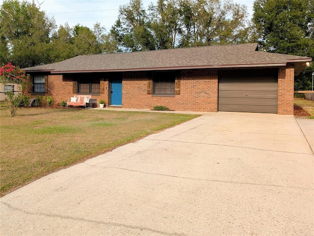 ranch-style home with a front lawn, concrete driveway, brick siding, an attached garage, and a shingled roof