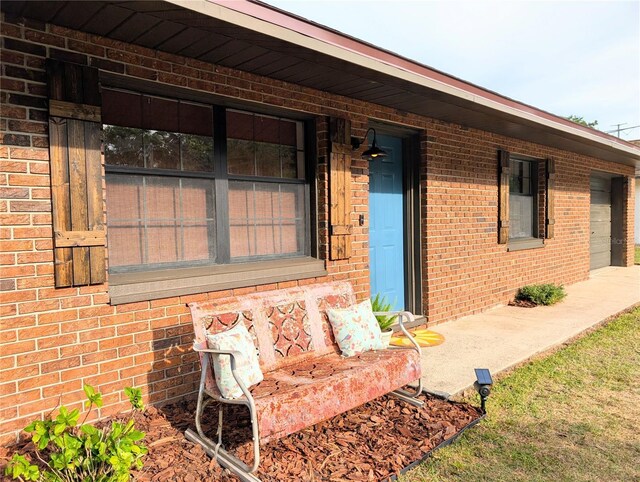 property entrance with brick siding and covered porch