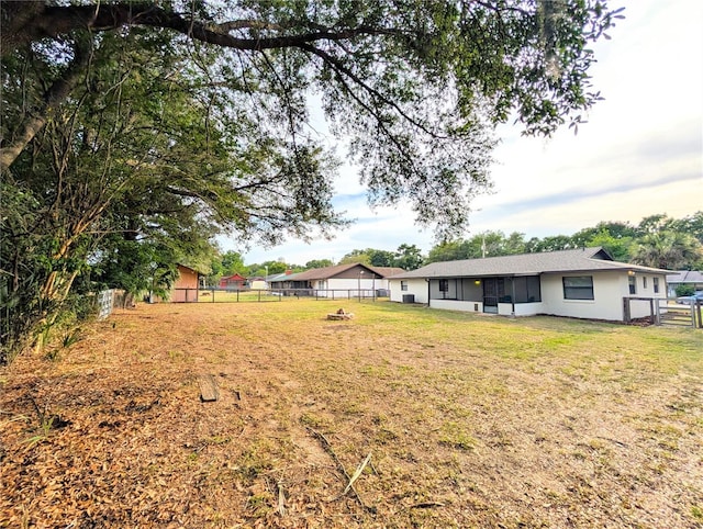 view of yard featuring a fenced backyard and a sunroom