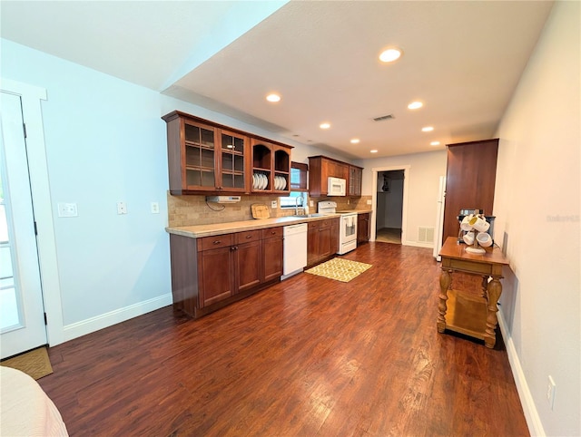 kitchen featuring light countertops, baseboards, dark wood-style flooring, and white appliances