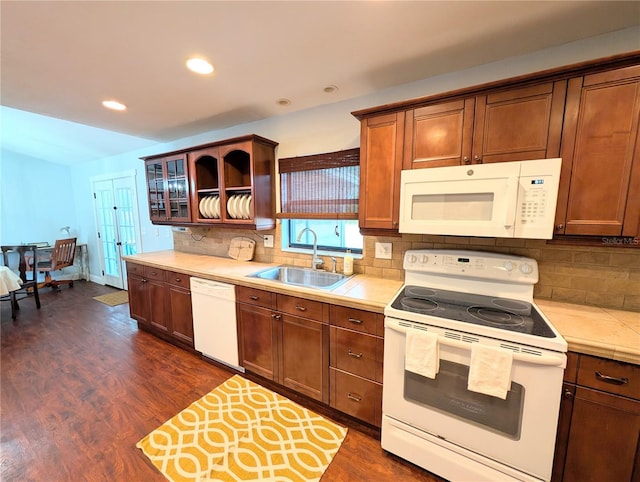 kitchen with light countertops, dark wood-style flooring, a sink, and white appliances