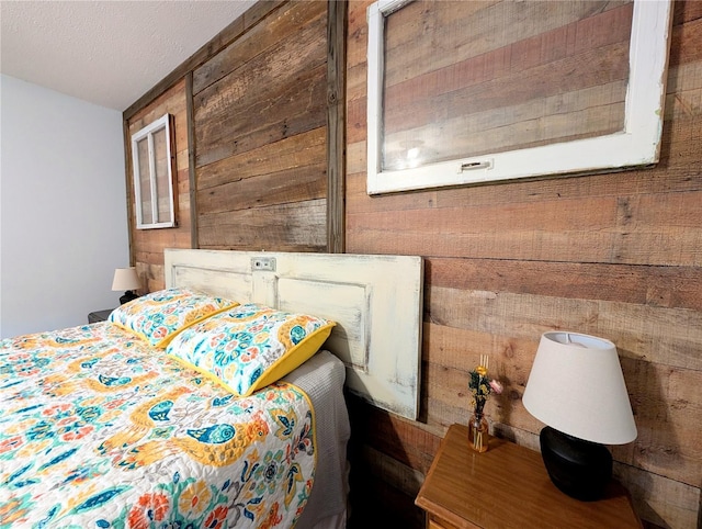 bedroom with a textured ceiling and wood walls