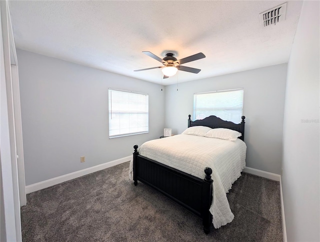 bedroom featuring dark colored carpet, visible vents, a ceiling fan, and baseboards
