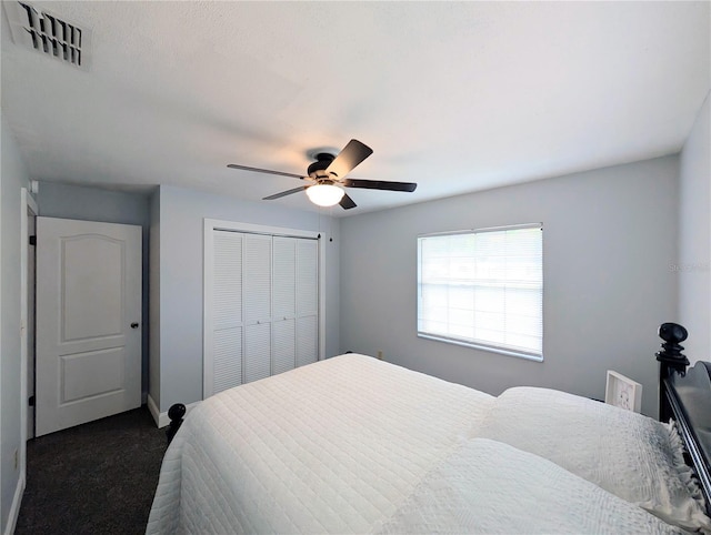bedroom with dark colored carpet, visible vents, a ceiling fan, a closet, and baseboards