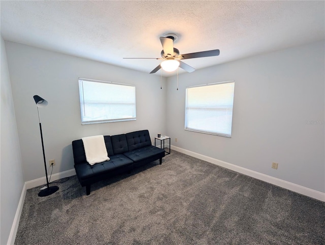 living area with baseboards, carpet floors, a textured ceiling, and ceiling fan