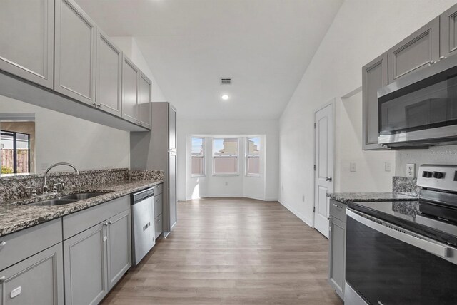 4246 NE 32nd Cir, Ocala, FL 34479 - kitchen featuring gray cabinets, light wood finished floors, a sink, and stainless steel appliances