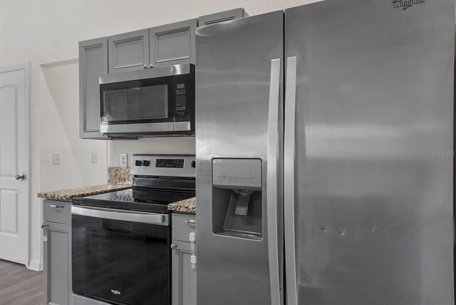 4246 NE 32nd Cir, Ocala, FL 34479 - kitchen featuring light stone counters, gray cabinetry, and stainless steel appliances
