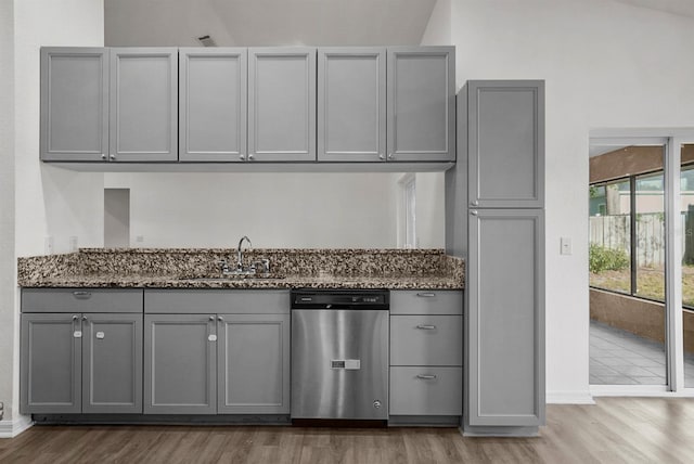 4246 NE 32nd Cir, Ocala, FL 34479 - kitchen featuring dark stone counters, wood finished floors, dishwasher, a sink, and gray cabinetry