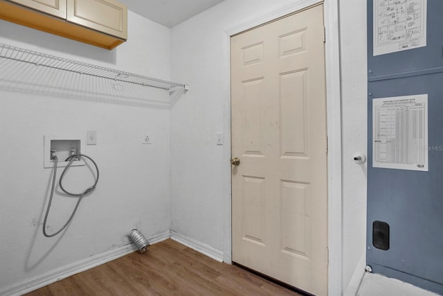 4246 NE 32nd Cir, Ocala, FL 34479 - washroom featuring baseboards, wood finished floors, hookup for a washing machine, and cabinet space