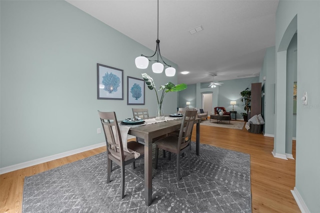 dining area featuring wood finished floors, visible vents, a ceiling fan, and baseboards