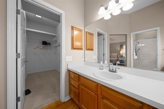 bathroom featuring walk in shower, a notable chandelier, vanity, and ensuite bathroom