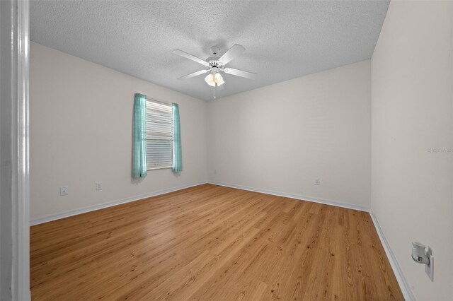unfurnished room featuring light wood-style floors, a textured ceiling, baseboards, and ceiling fan