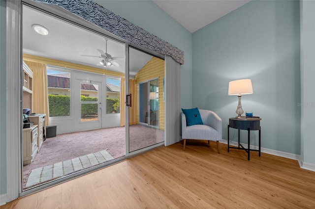 entryway featuring vaulted ceiling, wood finished floors, baseboards, and ceiling fan