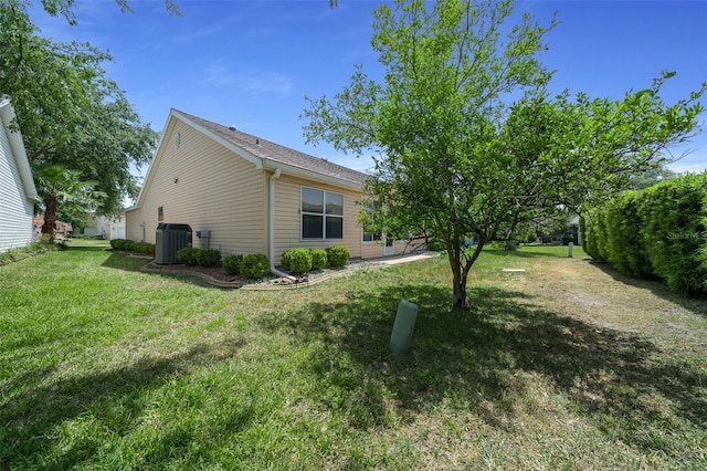 view of side of home with a yard and central air condition unit