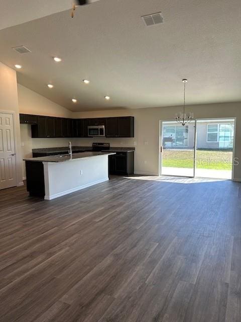 kitchen with stainless steel microwave, recessed lighting, dark countertops, dark wood-type flooring, and visible vents