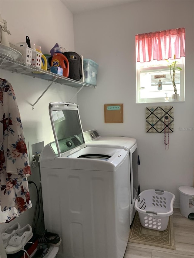 clothes washing area with washing machine and clothes dryer and laundry area