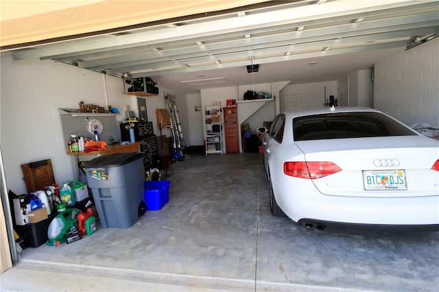 garage with a garage door opener and concrete block wall
