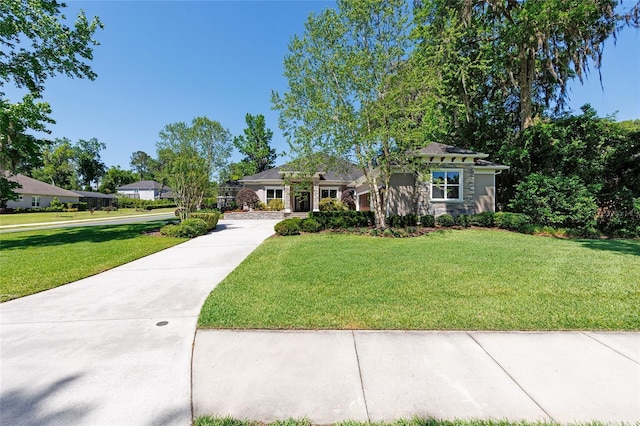 view of front of home featuring a front yard, driveway, stone siding, and stucco siding