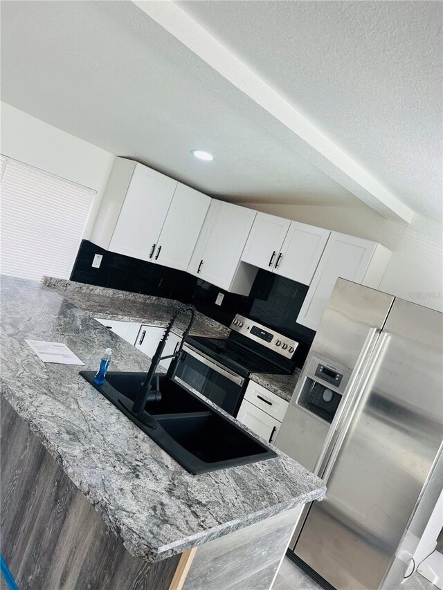 9247 SE 142nd Pl, Summerfield, FL 34491 - kitchen featuring light stone countertops, appliances with stainless steel finishes, a sink, and white cabinets