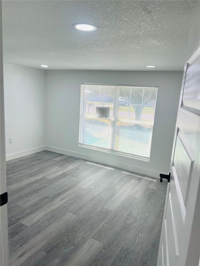9247 SE 142nd Pl, Summerfield, FL 34491 - unfurnished room with baseboards, a textured ceiling, and wood finished floors