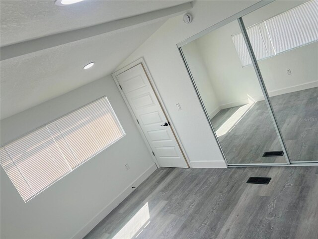 9247 SE 142nd Pl, Summerfield, FL 34491 - unfurnished bedroom with wood finished floors, baseboards, a closet, and lofted ceiling