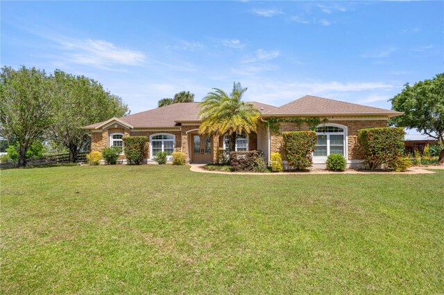 ranch-style house with a front yard and brick siding