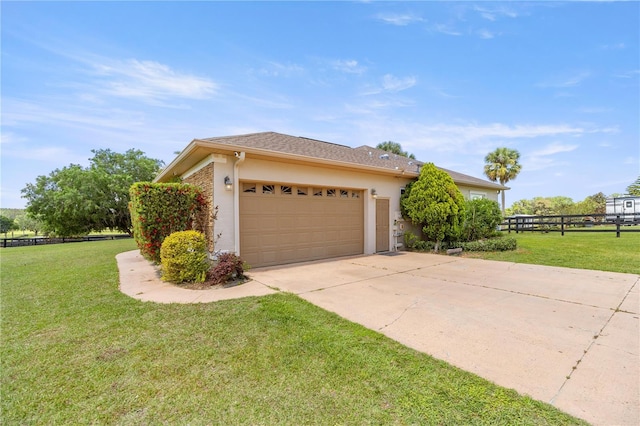view of side of home featuring a garage, a yard, driveway, and stucco siding