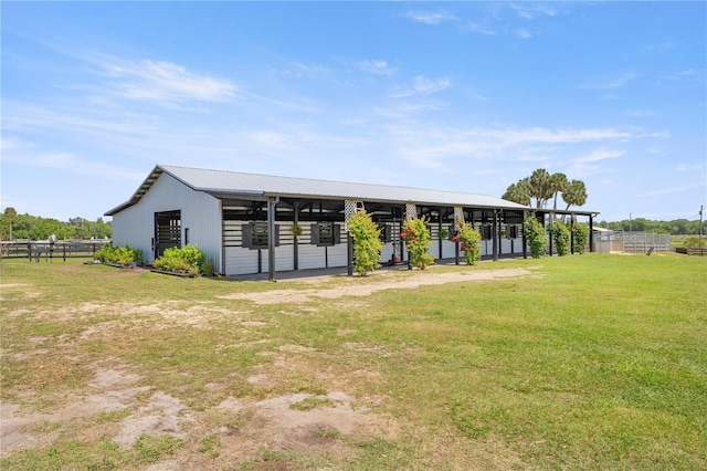 rear view of property featuring an exterior structure, metal roof, and an outdoor structure