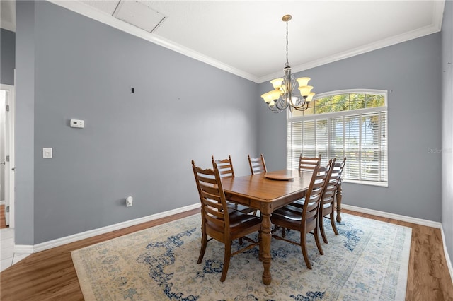 dining space featuring ornamental molding, baseboards, a chandelier, and wood finished floors