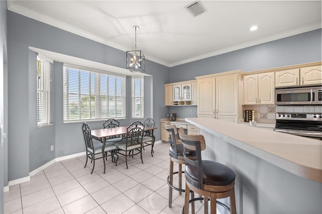kitchen featuring crown molding, light tile patterned floors, light countertops, and appliances with stainless steel finishes