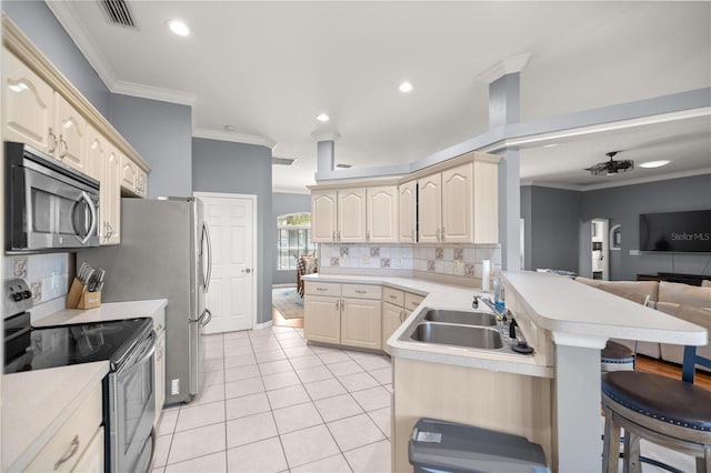 kitchen featuring a peninsula, ornamental molding, visible vents, a breakfast bar, and appliances with stainless steel finishes