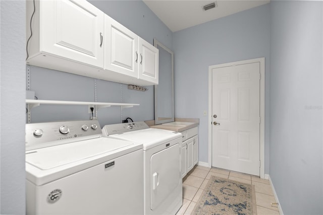 washroom featuring baseboards, light tile patterned flooring, visible vents, independent washer and dryer, and cabinet space