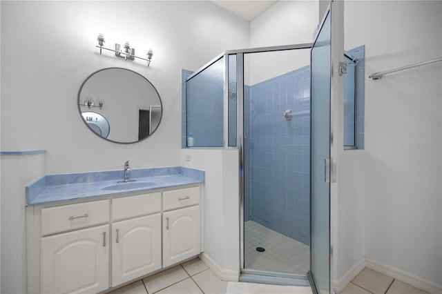 bathroom featuring tile patterned floors, vanity, and a stall shower